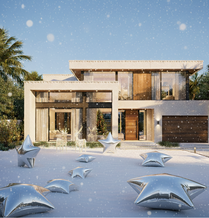 Modern house with decorative silver star sculptures in front on a snowy day.