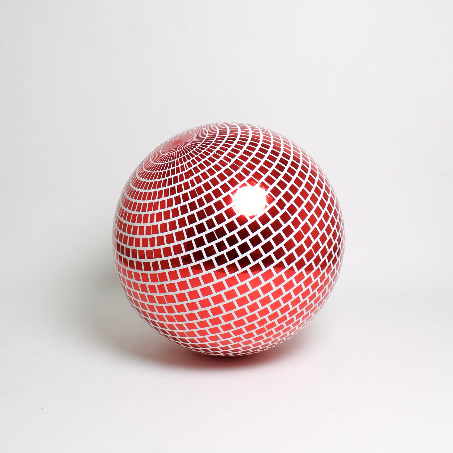 Red and white spherical object with a grid pattern on a light gray background