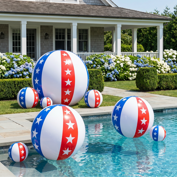 Inflatable beach balls with American flag design in a pool area with a house and garden in the background.
