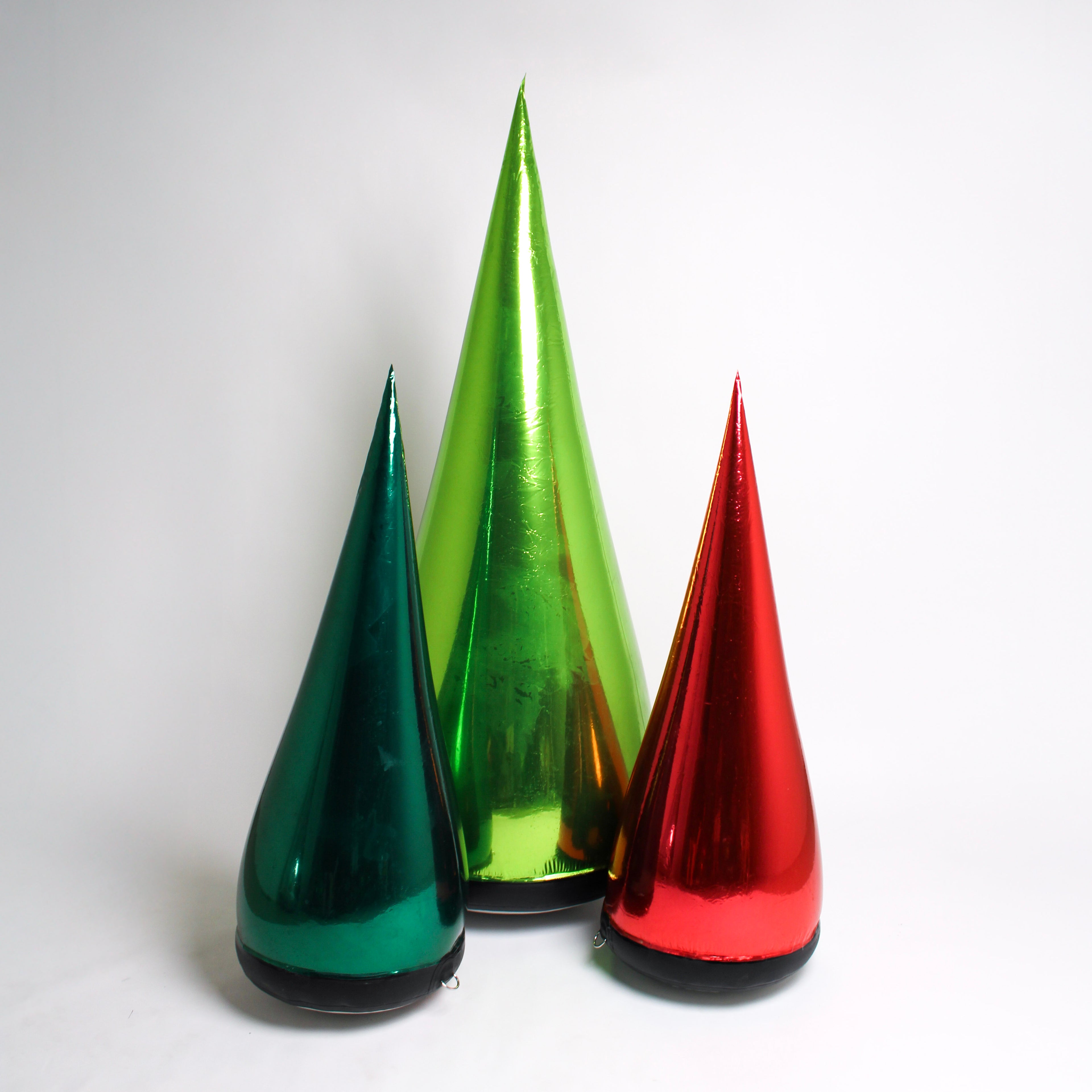Three metallic cone-shaped objects in green, red, and gold on a white background