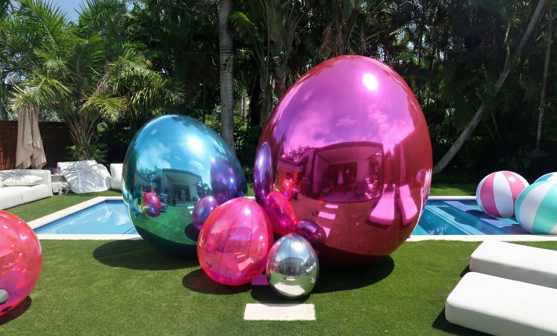 Colorful inflatable eggs on a grassy area near a pool