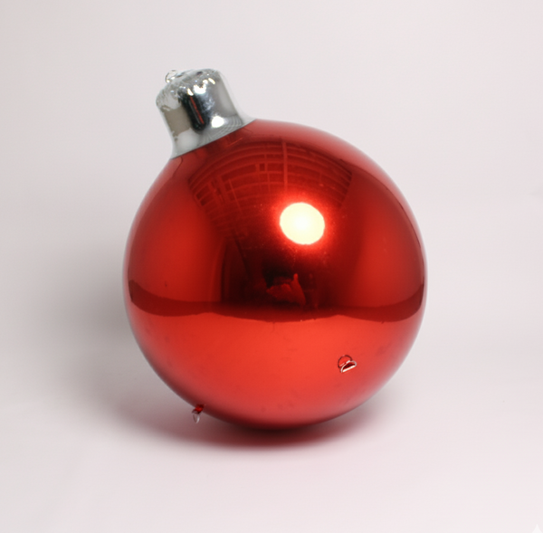 Red Christmas ornament with a silver top on a white background