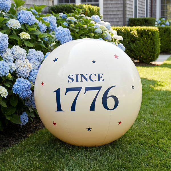 Decorative sphere with 'SINCE 1776' text in a garden setting